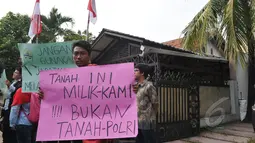 Warga perumahan Pati Polri membentangkan tulisan menolak penggusuran rumah mereka di Cipinang Baru Bunder, Jakarta, Selasa (26/5/2015). Sebanyak 6 rumah yang telah memiliki girik/bukti pembelian selama 48 tahun akan digusur. (Liputan6.com/Herman Zakharia)