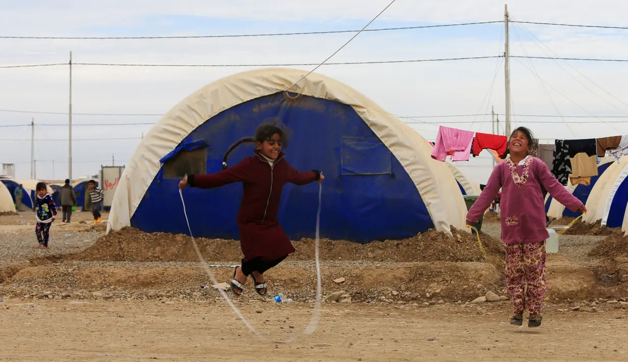 Anak-anak pengungsi Irak tertawa lepas saat bermain di kamp Khazer, Irak (5/12). Mereka melarikan diri akibat konflik peperangan antara pasukan koalisi Irak dengan ISIS. (REUTERS / Alaa Al-Marjani)