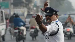 Polisi lalu lintas India Ranjeet Singh melakukan gerakan seperti tarian saat mengarahkan lalu lintas di persimpangan Indore, India (22/12). (AFP Photo/Indranil Mukherjee)