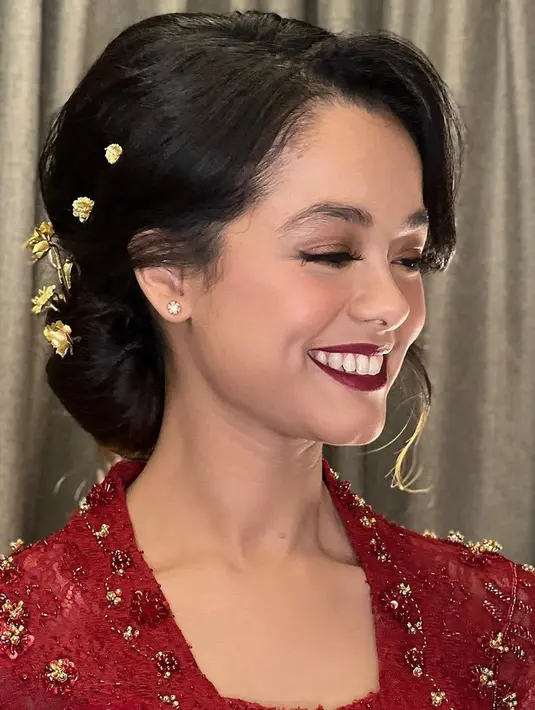 Rambut keriting perempuan kelahiran 3 Juni 1997 itu disanggul cepol dengan tusuk konde bermotif dedaunan sebagai aksesori. Sang makeup artist menyempurnakan dandanan Mutiara dengan lipstik warna senada kebaya. (Instagram/ochiipramita)