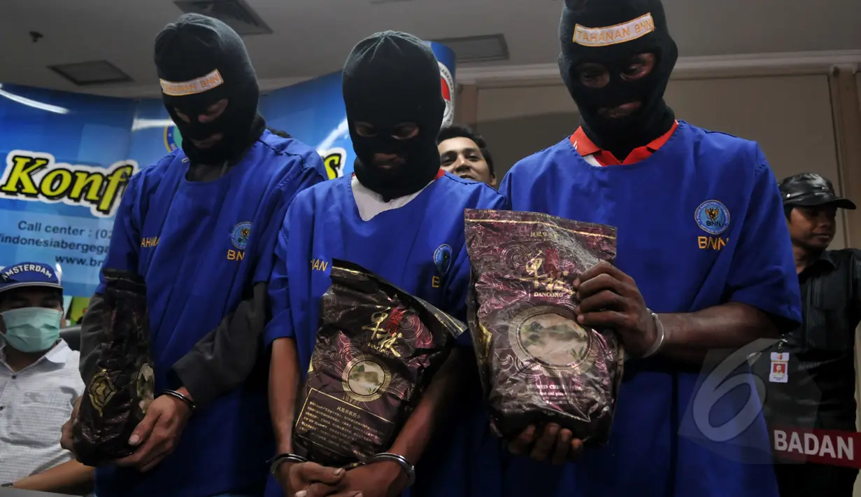 Tiga tersangka memegang barang bukti sabu saat konferensi pers di Kantor BNN, Jakarta, Kamis (16/4/2015). BNN menggagalkan transaksi narkotika jenis sabu seberat 10 kg dari Malaysia ke Indonesia. (Liputan6.com/Johan Tallo)