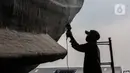 Aktivitas pekerja saat memperbaiki kapal di sebuah galangan kapal kawasan Muara Angke, Jakarta Utara, Kamis (3/6/2021). Banyaknya aktivitas dengan transportasi laut di pesisir utara Jakarta membuka peluang usaha perbaikan dan perawatan kapal laut. (Liputan6.com/Johan Tallo)