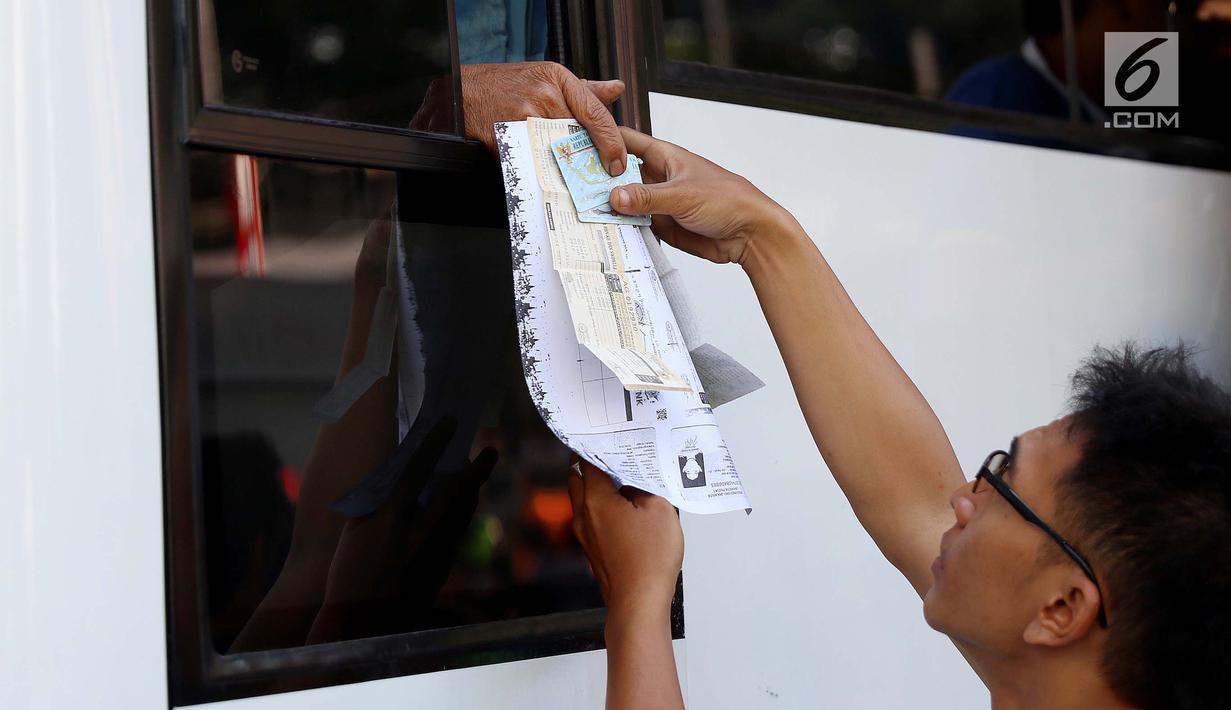 Warga menyerahkan dokumen saat membayar pajak kendaraan bermotor di samsat keliling di car free day, Jakarta, Minggu (27/8). Layanan pembayaran pajak STNK bisa dilakukan tanpa membawa salinan atau BPKB. (Liputan6.com/Angga Yuniar)