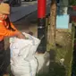 Dalam rangka merayakan Hari Peduli Sampah Nasional, seorang nenek di Makassar, mengumpulkan sampah yang berceceran di jalan. (Liputan6.com/Eka Hakim)