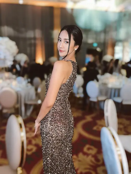 Anya Geraldine kali ini tampil glamor dengan gaun malam bernuansa emas. Gaun halter strap ini memiliki detail payet di seluruh bagian gaun. [instagram/anyageraldine]