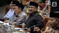 Menteri Agama Yaqut Cholil Qoumas (tengah) saat membahas draft penetapan biaya haji 2023 dalam rapat panja bersama Komisi VIII DPR RI di kompleks Parlemen, Senayan, Jakarta, Rabu (15/2/2023). Pemerintah bersama legislator menyepakati biaya haji yang harus dibayarkan jemaah sebesar Rp 49.812.700. Angka itu disepakati dalam rapat Panja Haji Komisi VIII DPR dengan Panja Haji pemerintah yang terdiri dari Kemenag, BPKH, dan pihak-pihak terkait lainnya di Kompleks Parlemen, Jakarta, Rabu (15/2). (Liputan6.com/Faizal Fanani)