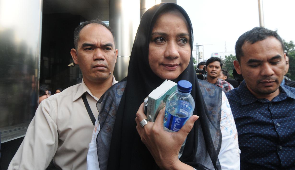 Istri Gubernur Aceh nonaktif Irwandi Yusuf, Darwati Agani  meninggalkan Gedung KPK seusai menjalani pemeriksaan di Jakarta, Selasa (31/7). Usai pemeriksaan, Darwati memilih bungkam saat ditanya kasus yang menjerat suaminya. (Merdeka.com/Dwi Narwoko)