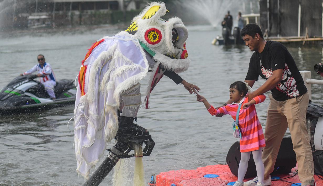 Sebelumya, pertunjukan ini sebelumnya telah sukses memukau penonton di Guangxi, China, dan Sydney, Australia, sebelum akhirnya hadir secara perdana di Jakarta. Tampak dalam foto, penampil mengenakan kostum barongsai beratraksi Aerial Lion Dance di Danau Senayan Park, Jakarta, 14 Februari 2026. (merdeka.com/Arie Basuki)