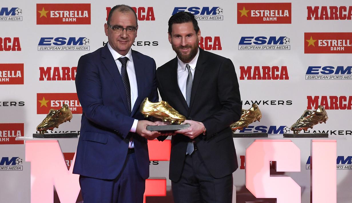 Striker Barcelona, Lionel Messi, bersama direktur Marca berpose saat menerima trofi Sepatu Emas Eropa di Antiga Fabrica Estrella Damm, Selasa, (18/12/2018). Messi berhak atas penghargaan itu berkat koleksi 34 gol dari 36 pertandingan. (AFP/Lluis Gene)