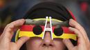 Seorang suporter Jerman memegang kacamatanya saat laga Grup E antara Jerman melawan Jepang di Khalifa International Stadium, Doha, Qatar, Rabu (23/11/2022). (AP/Matthias Schrader)