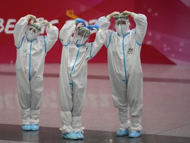 Pekerja Olimpiade dengan pakaian pelindung berpose di bandara Beijing Capital International setelah Olimpiade Musim Dingin 2022, di Beijing, China, Senin (21/2/2022). (APhoto/Frank Augstein