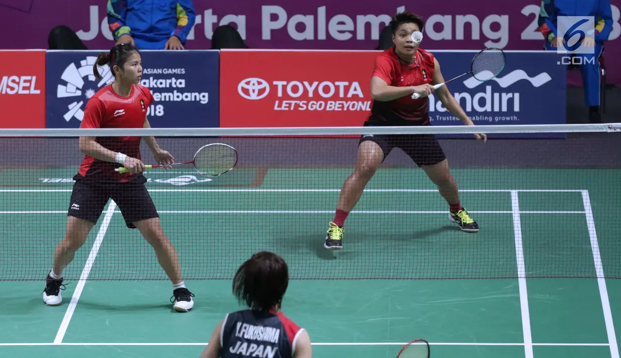 Ganda putri Indonesia, Greysia Polii/Apriyani Rahayu mengembalikan kok ke arah pemain Jepang, Yuki Fukushima/Sayaka Hirota pada semifinal Bulutangkis Beregu Putri Asian Games 2018 di Jakarta, Selasa (21/8). (Liputan6.com/Helmi Fithriansyah)