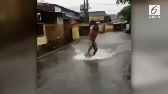 VIDEO: Kocak, Pria Ini Berselancar di Tengah Banjir