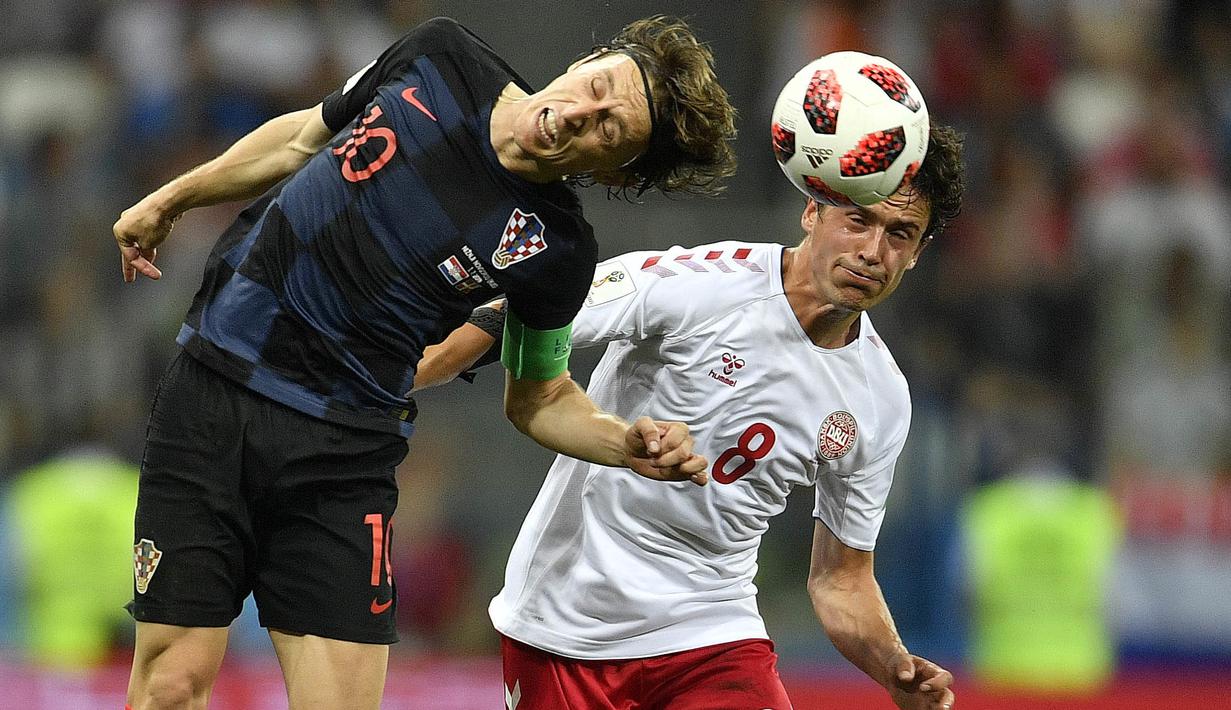 Duel pemain Kroasia, Luka Modric (kiri) dan pemain Denmark, Thomas Delaney pada laga 16 besar Piala Dunia 2018 di Nizhny Novgorod Stadium, Rusia, (1/7/2018). Kroasia menang 3-2 lewat adu penalti. (AP/Martin Meissner)
