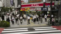 Komuter menunggu untuk menyeberang jalan menjelang Olimpiade 2020 di Tokyo, Jepang, Rabu (14/7/2021). Keadaan darurat akan berlaku sepanjang Olimpiade yang dibuka pada 23 Juli. (AP Photo/Jae C. Hong)