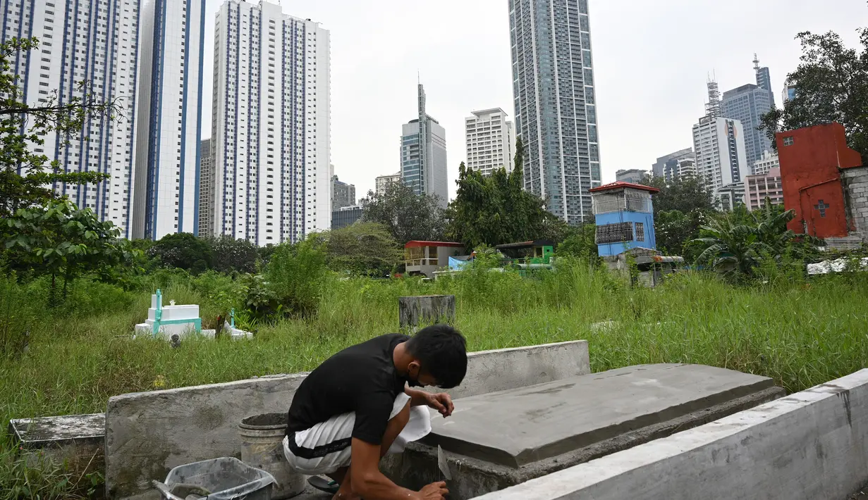 Seorang pekerja menghadiri pemakaman di sebuah pemakaman di Manila, Filipina (28/10/2021). Pemerintah setempat akan menutup pemakaman nasional untuk Hari Semua Orang Kudus karena pandemi virus corona Covid-19. (AFP/Ted Aljibe)