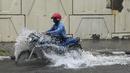 Pengendara motor melewati jalan yang tergenang air saat hujan lebat di New Delhi, India (1/9/2021). Polisi Lalu Lintas Delhi mengeluarkan peringatan yang menginformasikan bahwa ada penghalang lalu lintas di Subway Pasar Azad menuju Pratap Nagar karena genangan air. (AFP/Prakash Singh)
