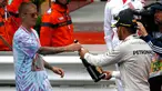 Pembalap Mercedes F1 Lewis Hamilton memberikan sampanye kepada penyanyi Justin Bieber usai berhasil menjuarai Grand Prix di Monaco, (29/5). Hamilton menjadi yang tercepat dengan mencatatkan waktu satu jam 59 menit 29,133 detik. (REUTERS/Eric Gaillard)