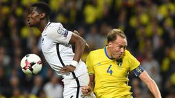 Gelandang Prancis, Paul Pogba, duel udara dengan bek Swedia, Andreas Granqvist, pada laga kualifikasi Piala Dunia 2018 di Stadion Friends Arena, Solna, Jumat (9/6/2017). Swedia menang 2-1 atas Prancis. (AFP/Franck Fife)