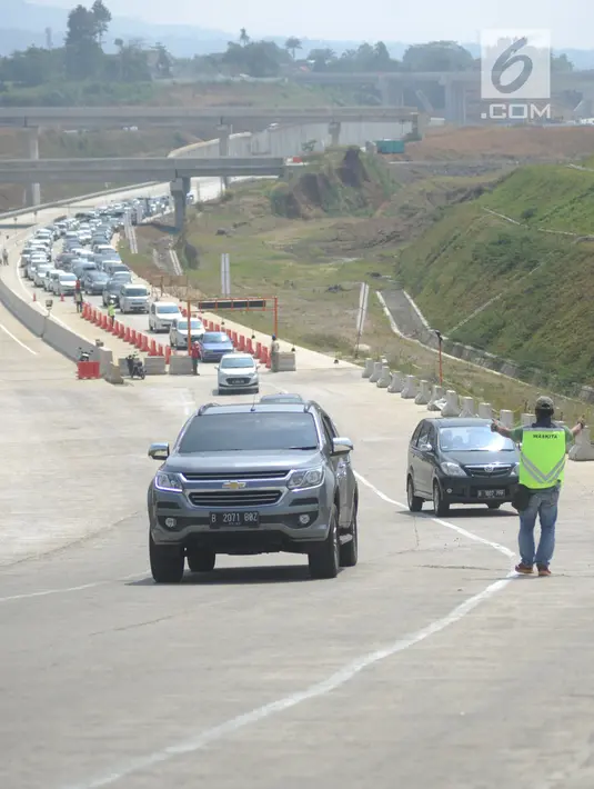 Petugas dari PT Waskita Karya mengatur kendaraan saat pola buka tutup pada ruas tol fungsional Bogor-Sukabumi di Cigombong, Bogor (16/6). Kemacetan terjadi sepanjang lebih dari lima kilometer pada jalan arteri Ciawi-Sukabumi. (Merdeka.com/Arie Basuki)