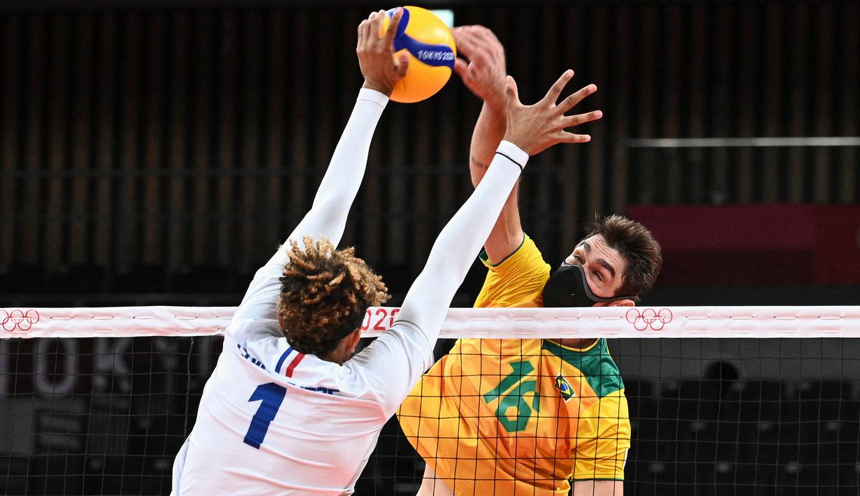 Pevoli Brasil, Lucas Saatkamp (kanan) memukul bola saat penyisihan grup B bola voli putra Olimpiade Tokyo 2020 antara Brasil dan Prancis di Ariake Arena pada 1 Agustus 2021. Lucas Saatkamp mengaku menggunakan masker saat berlaga demi melindungi dirinya dan keluarganya. (Anne-Christine POUJOULAT/AFP)