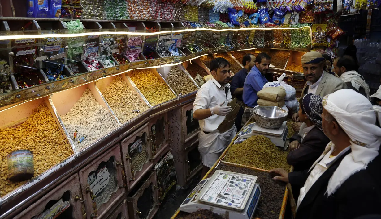 Warga membeli kacang-kacangan dan makanan manis di sebuah pasar menjelang Hari Raya Idul Fitri di Sanaa, Yaman, Jumat (22/5/2020). Idul Fitri menandai berakhirnya bulan suci Ramadan. (Xinhua/Mohammed Mohammed)