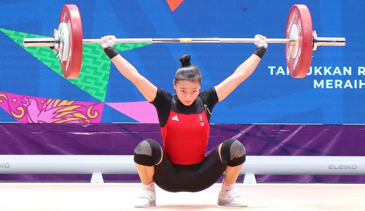 Lifter putri Jawa Barat, Windy Cantika Aisah, saat beraksi pada nomor 49 kg di PON XX Papua di Auditorium Universitas Cendrawasih Jayapura, Rabu (6/10/2021). Cindy meraih medali emas dengan total angkatan 192kg. (Foto: PB PON XX PAPUA/Dadang Tri)
