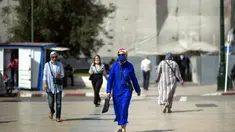 Orang-orang memakai masker saat mereka berjalan di pusat kota Rabat, Maroko, Jumat (1/10/2021). Maroko melonggarkan beberapa tindakan pembatasan yang terjadi selama musim panas karena telah memvaksinasi lebih dari 50 persen populasinya. (AP Photo/Mosa'ab Elshamy)