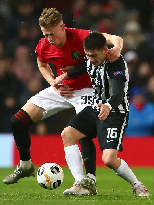 Gelandang Manchester United (MU), Scott McTominay berebut bola dengan pemain Partizan, Sasa Zdjelar  pada matchday keempat Grup L Liga Europa di Old Trafford, Kamis (7/11/2019). Tampil di hadapan pendukungnya sendiri, MU mengalahkan Partizan Belgrade 3-0. (AP/Dave Thompson)