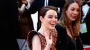 Aktris Emma Stone menyapa fans saat tiba menghadiri perhelatan Piala Oscar 2019 di Teater Dolby di Los Angeles, AS (24/2). Emma Stone tampil cantik mengenakan gaun emas seperti sarang lebah Louis Vuitton. (AFP Photo/Eric Jamison)