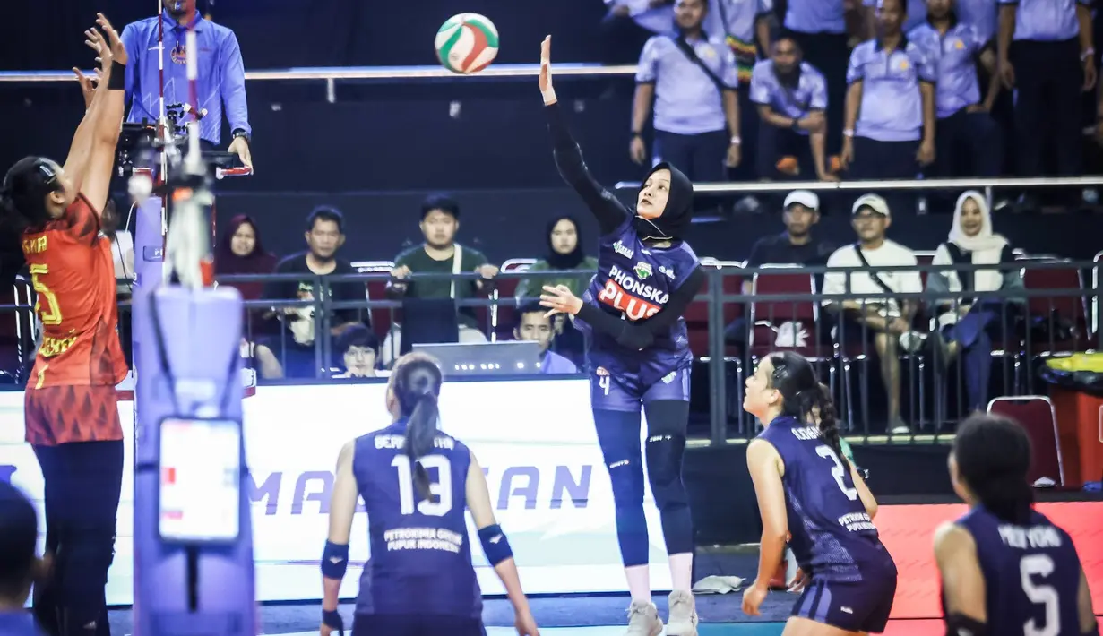 Pemain Petrokimia Gresik Pupuk Indonesia mencoba melakukan spike ke daerah TNI AU Electric pada Final Four Livoli Divisi Utama 2025 yang bertempat di GOR Ki Mageti, Magetan Rabu (15/10/2025).