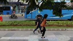 Pejalan kaki bermain permainan anak engkle di trotoar sekitar Halte Gelora Bung Karno, Jakarta, Jumat (17/5/2019). Koalisi Pejalan Kaki melakukan eksperimen permainan untuk mengedukasi kegiatan mengembalikan fungsi trotoar lebih dari sekedar ruang berjalan kaki. (Liputan6.com/Helmi Fithriansyah)