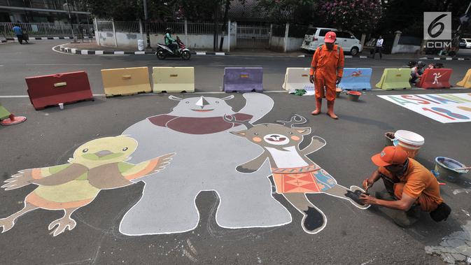 Petugas PPSU menggambar maskot Asian Games 2018 di Jalan Penataran atau Simpang Tugu Proklamasi, Jakarta, Rabu (25/7). Pembuatan maskot dan logo Asian Games 2018 dalam rangka menyambut event terbesar se-Asia tersebut. (Merdeka.com/Iqbal S. Nugroho)