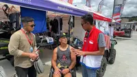 Area Manager Comm, Rel & CSR Pertamina Patra Niaga Sumbagut, Susanto August Satria, berbincang dengan pembalap dari Amerika Serikat, Anthony Radetic, di Samosir (Reza Efendi/Liputan6.com)