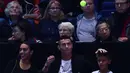 Pemain Juventus, Cristiano Ronaldo mengembalikan bola tenis yang mengarah kepadanya dan sang kekasih, Georgina saat menyaksikan Novak Djokovic menghadapi John Isner pada laga tenis dunia, ATP Finals 2018 di O2 Arena, London, Senin (12/11). (Glyn KIRK/AFP)