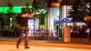 Seorang polisi mengamankan daerah sekitar pusat perbelanjaan Olympia Einkaufzentrum OEZ di Munich, Jerman (22/7). Pusat perbelanjaan ini berada di samping stadion Munich Olympic. (AFP PHOTO/Stringer)