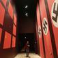 Pengunjung melintas dilorong bergambarkan bendera Nazi dan Soivet di Museum Perang Dunia 2 di Gdansk, Polandia, 23/1). Museum ini satu-satunya yang merekam sejarah Polandia saat Perang Dunia II. (AP/Czarek Sokolowski)