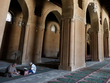 Dua orang pria memanfaatkan bulan suci Ramadan dengan membaca Al Quran di Masjid Ibnu Tulun, Kairo, 2 Juni 2017. Masjid yang dibangun pada 876-879 di masa pemerintahan Ahmad Ibn Tulun ini merupakan masjid tertua kedua di Mesir (REUTERS/Amr Abdallah Dalsh)