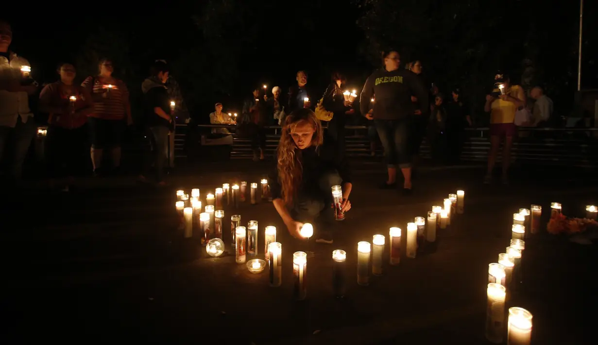 Sejumlah warga memegang lilin saat mengikuti aksi solidaritas terhadap penembakan masal di Umpqua Community College, Roseburg, Oregon, (1/10/2015). Pelaku penembakan tewas saat terlibat baku hantam dengan polisi. (REUTERS/Steve Dipaola)