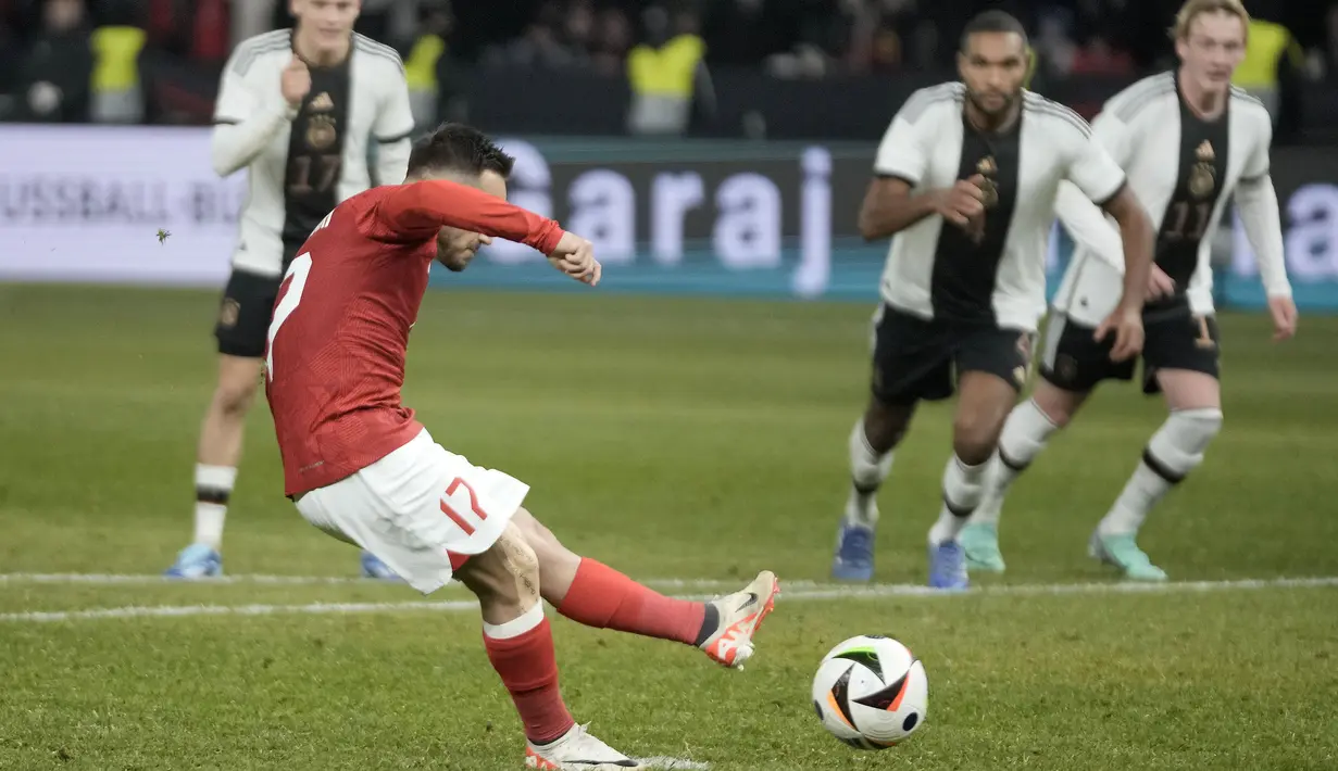 Striker Timnas Turki, Yusuf sari mencetak gol ketiga ke gawang Timnas Jerman melalui eksekusi penalti pada laga uji coba internasional di Olympiastadion, Berlin, Minggu (19/11/2023) dini hari WIB. (AP Photo/Markus Schreiber)