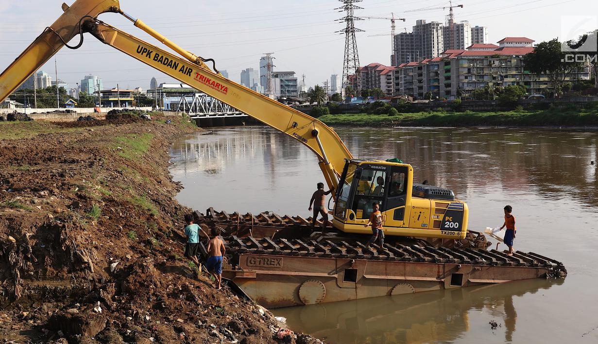 Anak-anak bermain di atas alat berat di Kanal Banjir Barat, Jakarta, Jumat (23/3). Anak-anak nekat bermain di lokasi ini meski berbahaya bagi kesehatan dan keselamatan. (Liputan6.com/Immanuel Antonius)