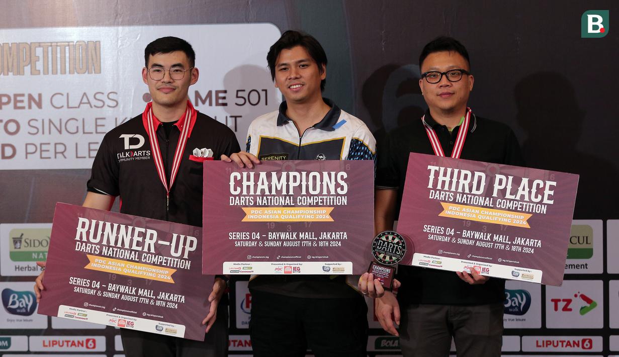 Putra Fajar Utama (tengah) berfoto bersama dengan peraih peringkat kedua dan ketiga Darts National Competition 2024 series 4 di Baywalk Mall, Jakarta Utara, Minggu (18/08/2024). (Bola.com/Agri Aulian Perdana)