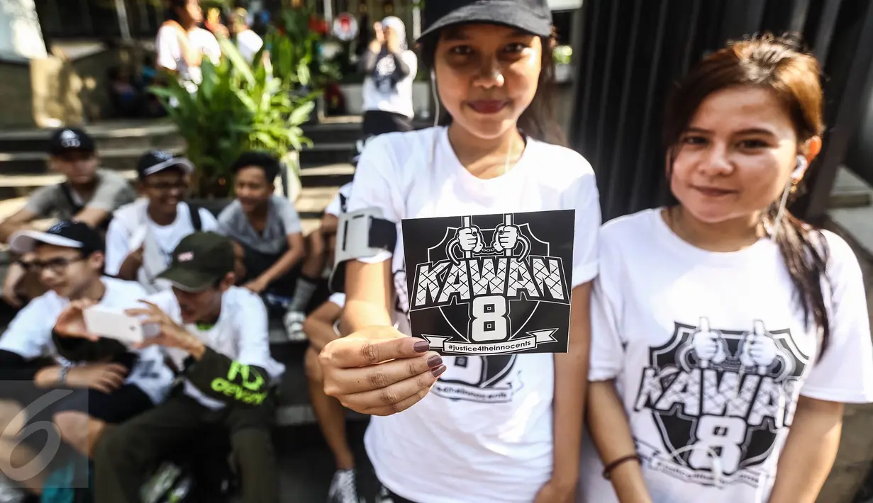 Dua pemudi menunjukkan stiker kawan8 saat Car Free Day di Senayan, Jakarta, Minggu (24/7). Kawan8 merupakan relawan netizen untuk membela 8 orang korban Jakarta International School yang mencuat pada tahun 2014. (Liputan6.com/Fery Pradolo)