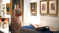 Ratu Inggris Elizabeth II melihat lukisan Ratu Victoria dan Pangeran Albert oleh Louis Haghe sebagai bagian dari pameran di Istana Buckingham, London, Rabu (17/7/2019). Pameran yang dibuka pada 20 Juli ini menandai peringatan 200 tahun kelahiran Ratu Victoria. (Victoria Jones/POOL/AFP)