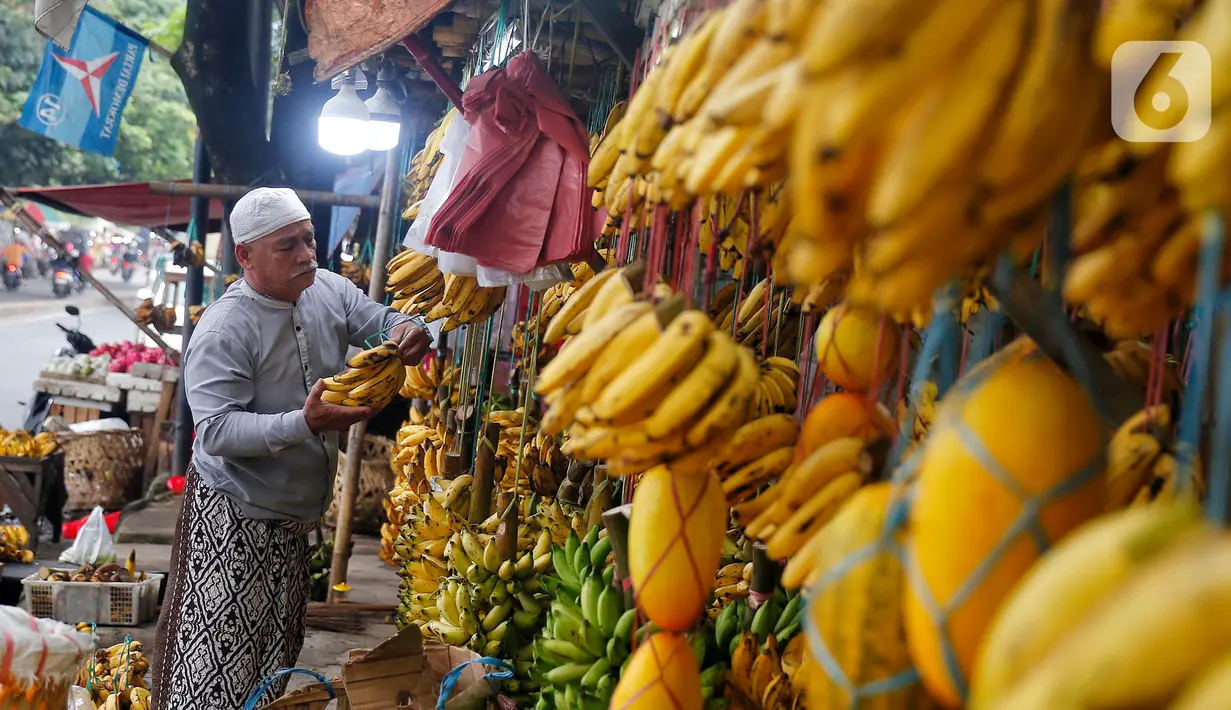 Seorang warga memilih pisang yang digantung. (Liputan6.com/Angga Yuniar)