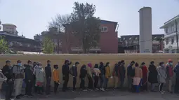Antrean warga Nepal untuk vaksinasi covid-19 di sebuah rumah sakit di Kathmandu,  Rabu (19/1/2022). Nepal, penyangga alami antara Cina dan India, telah melakukan vaksinasi ganda terhadap 39,9 persen dari 30 juta penduduknya dalam kampanye yang dimulai awal tahun lalu. (AP Photo/Niranjan Shrestha)