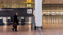 Seorang penumpang melihat layar informasi keberangkatan di Bandara Brussels, Zaventem, Belgia, Rabu (13/2). Menurut badan lalu lintas udara Skeyes, pembatalan penerbangan di Belgia berkaitan dengan aksi mogok nasional. (AP Photo/Geert Vanden Wijngaert)