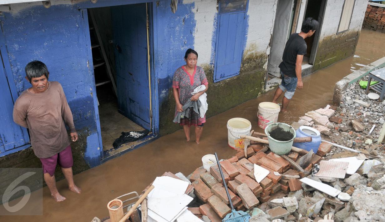Warga mebersihkan sisa-sisa endapan lumpur di rumahnya, Cawang, Jakarta, Senin (7/11). Sebelumnya, ratusan rumah warga di RW 02 Cawang, Kramat Jati, Jakarta Timur tergenang akibat banjir kiriman dari kawasan Bogor. (Liputan6.com/Yoppy Renato)