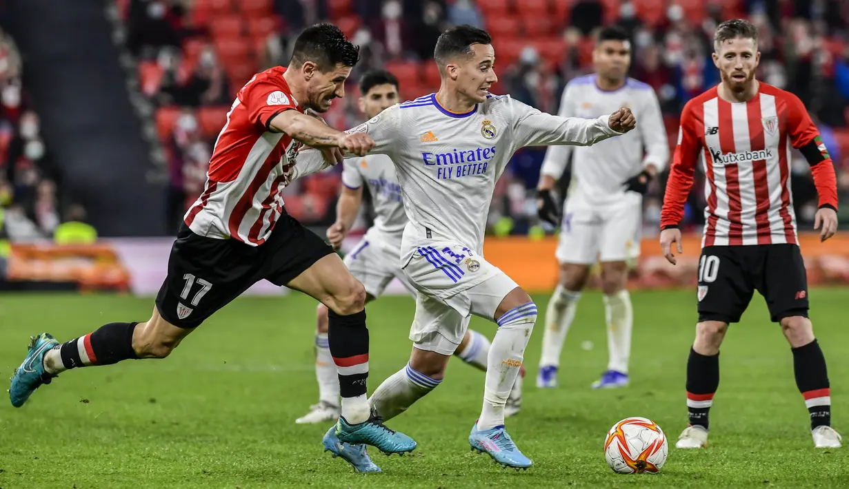 Gelandang Real Madrid Lucas Vazquez berebut bola dengan bek Athletic Bilbao Yuri Berchiche pada perempat final Copa del Rey di San Mames, Jumat (4/2/2022) dinihari WIB. Real Madrid tersisih dari Copa del Rey setelah kalah 0-1 dari Athletic Bilbao. (AP Photo/Alvaro Barrientos)