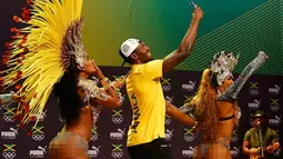 Pelari asal Jamaika, Usain Bolt berselfie dengan penari samba saat konferensi pers cabang atletik Olimpiade Rio 2016 di Rio de Janeiro, Brasil, (8/8). Pelari 29 tahun ini merupakan pelari pria tercepat di dunia. (REUTERS/Nacho Doce)